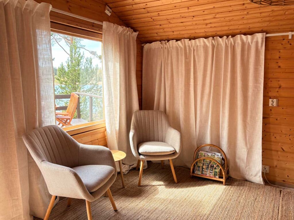 Vierasmökin viihtyisä nurkka jossa on pöytä ja kaksi nojatuolia.